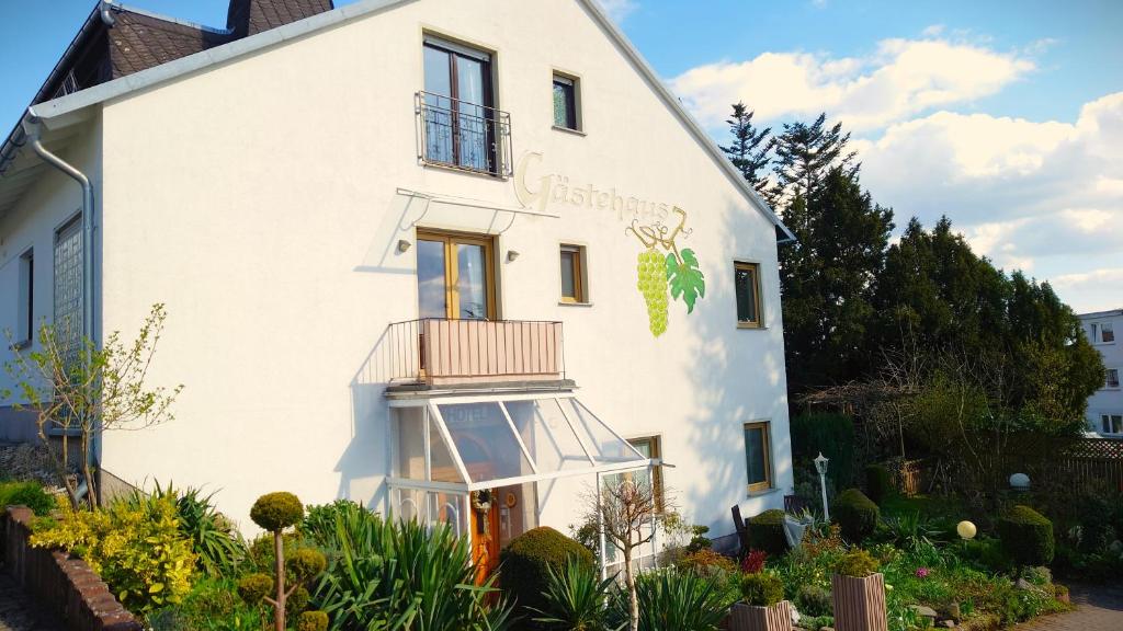 Una casa blanca con un balcón en el lateral. en Hotel Garni Zur Traube en Höhr-Grenzhausen