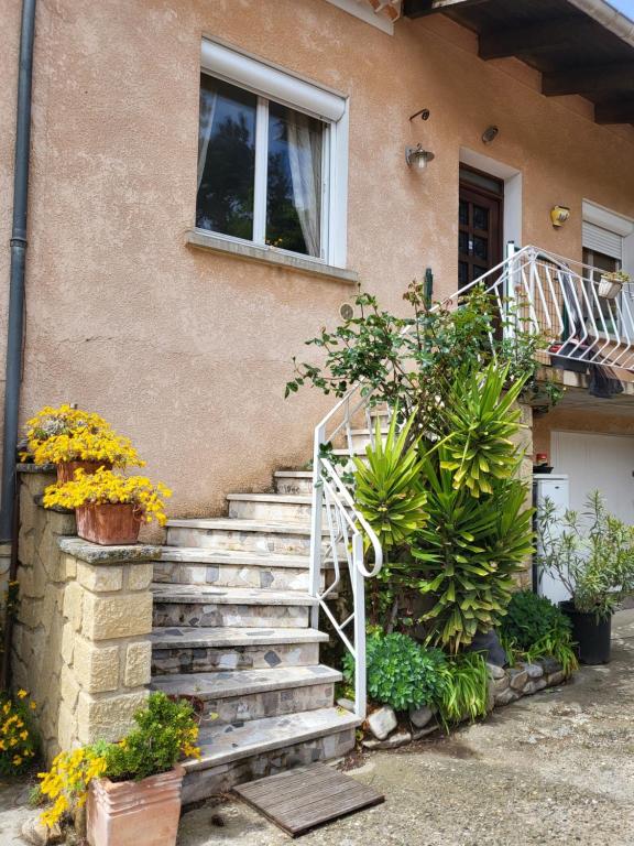 a set of stairs in front of a house with flowers at Domaine du gros pata in Vaison-la-Romaine