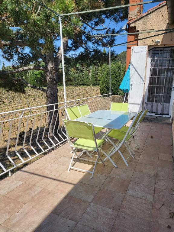 une table et des chaises assises sur une terrasse dans l'établissement Domaine du gros pata, à Vaison-la-Romaine