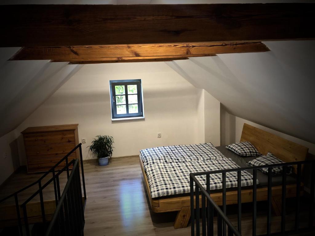 Pokój na poddaszu z łóżkiem i oknem w obiekcie Mezonetový apartmán s terasou na samotě v lese w mieście Vlkava