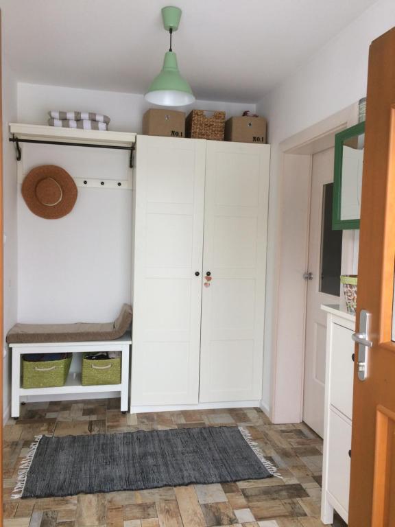 a kitchen with white cabinets and a rug at Green place in Žetale