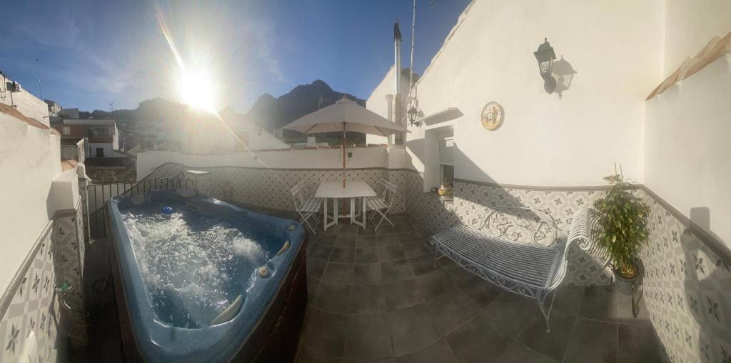 balcón con bañera, mesa y sillas en Casa Las Aguilas, en Montejaque
