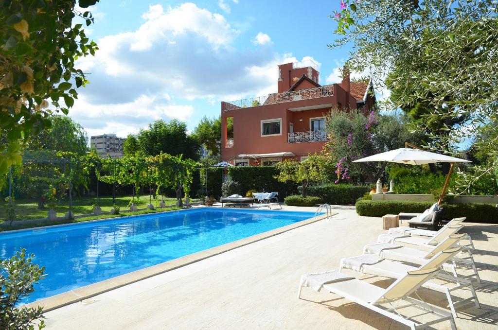a swimming pool with chairs and a house at Villa Luisa in Bari