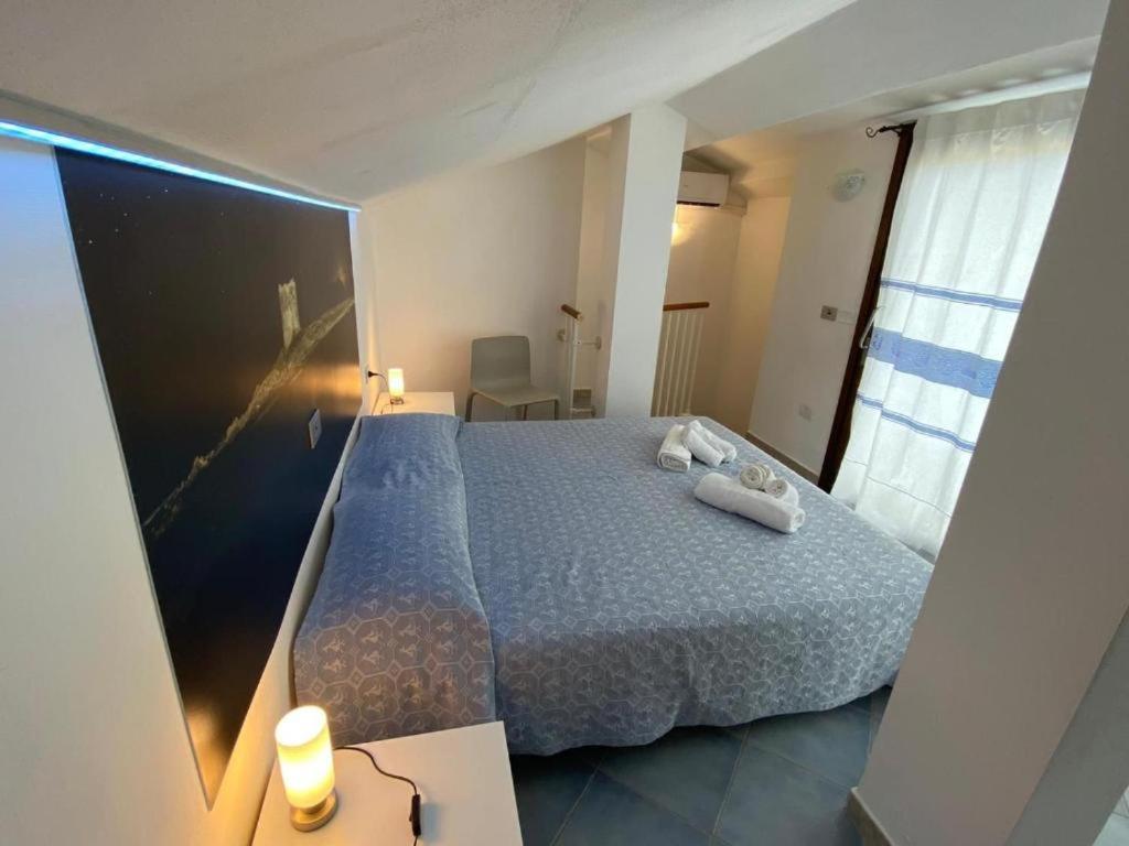 a bedroom with a bed with a blue comforter at 103 Boutique Hotel Stintino in Stintino