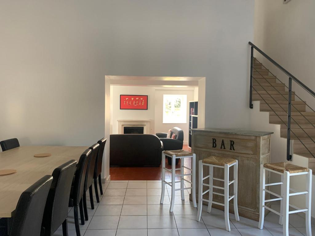 una habitación con una mesa y sillas y un bar en Gîte le cœur de Givry, en Givry