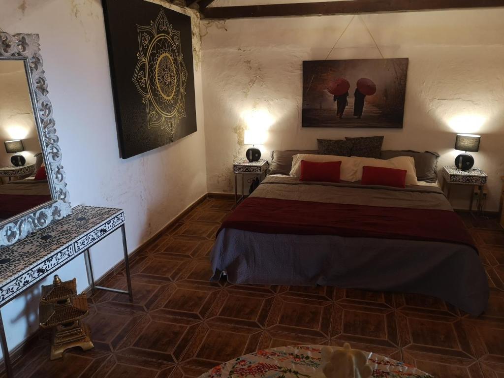 1 dormitorio con cama y espejo en la pared en Suite Zen y Cueva Refugio, en Tenteniguada