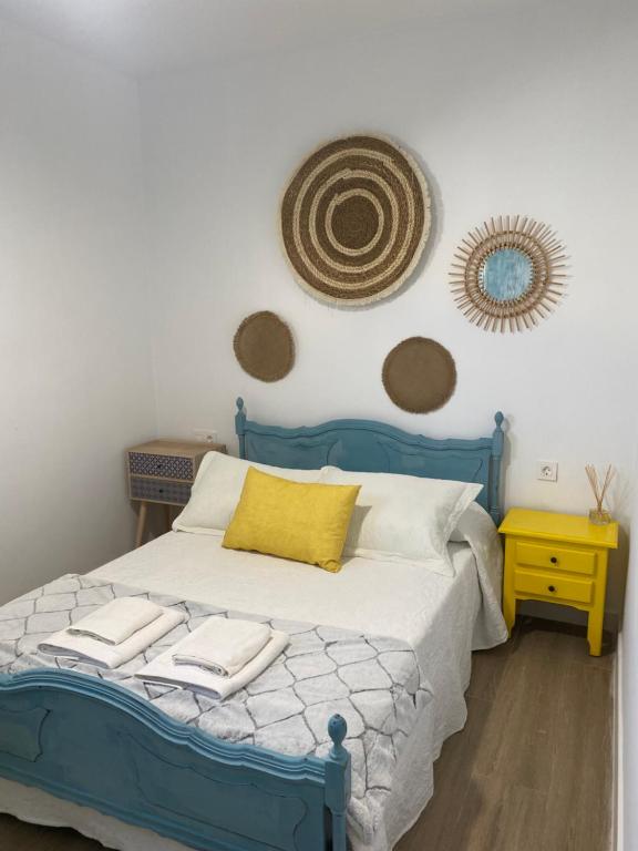 een slaapkamer met een blauw bed en handdoeken bij Apartamento Los Escullos in Los Escullos