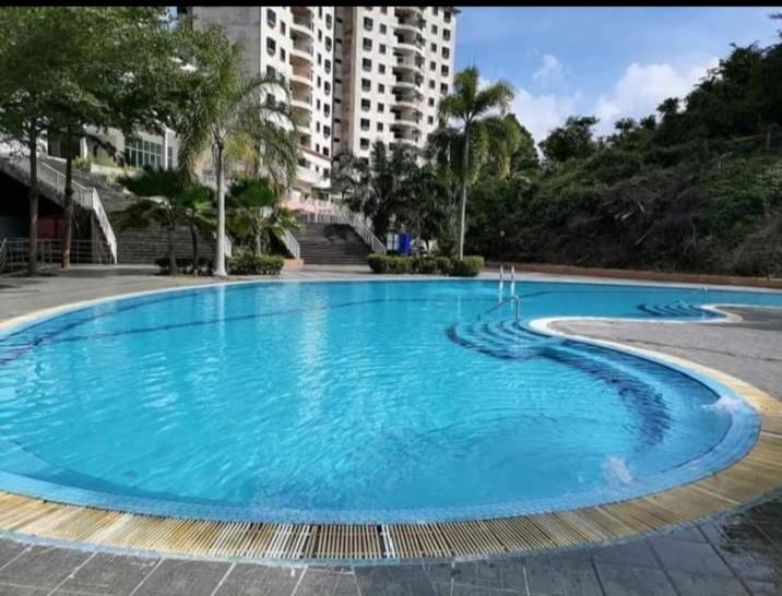 a large blue swimming pool in front of a building at Lumut Valley in Lumut