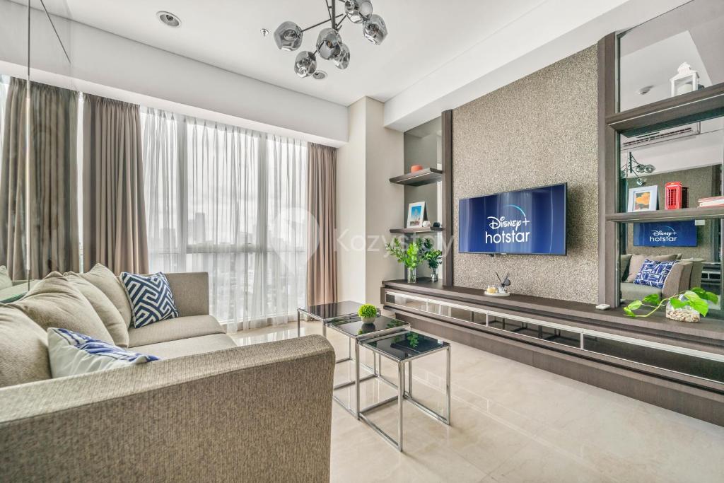 a living room with a couch and a tv at LONDON by Kozystay - Kuningan in Jakarta