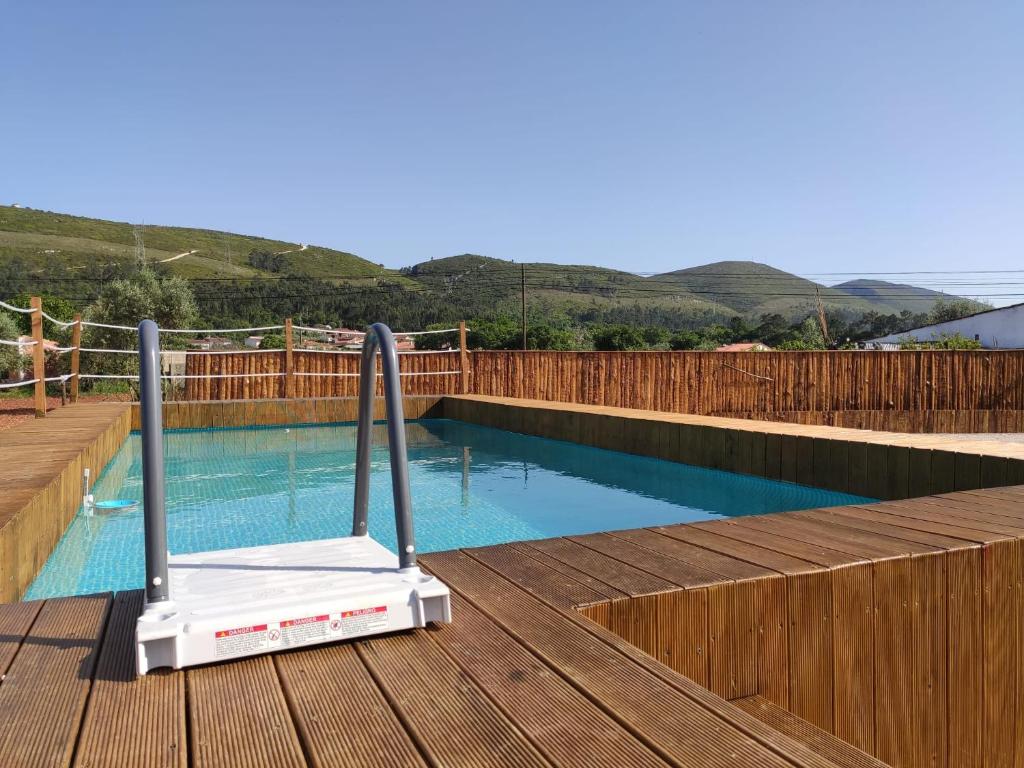 a swimming pool with a treadmill on a wooden deck at Renovated Wine Press House - WITH POOL in Porto de Mós
