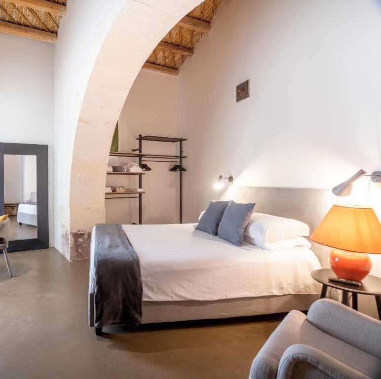 Postel nebo postele na pokoji v ubytování PALAZZO TRIGONA DEPENDANCE