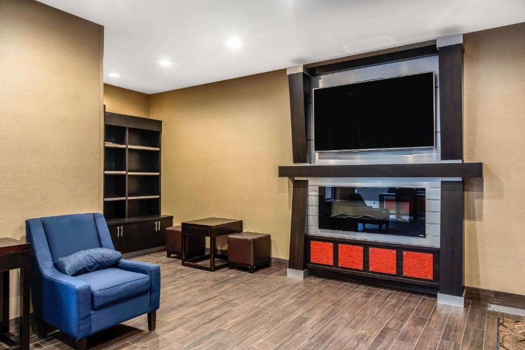 uma sala de estar com uma televisão de ecrã plano e uma cadeira azul em Comfort Suites San Jose Airport em San José