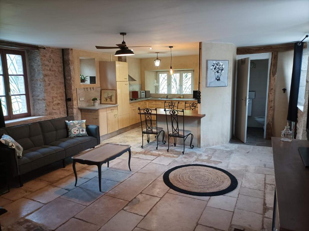 a living room with a couch and a table at La maison du meunier avec terrain de pétanque in Autigny-la-Tour