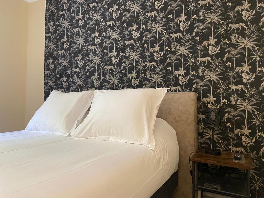 um quarto com uma cama com papel de parede preto e branco em Hotel Regina em Sète
