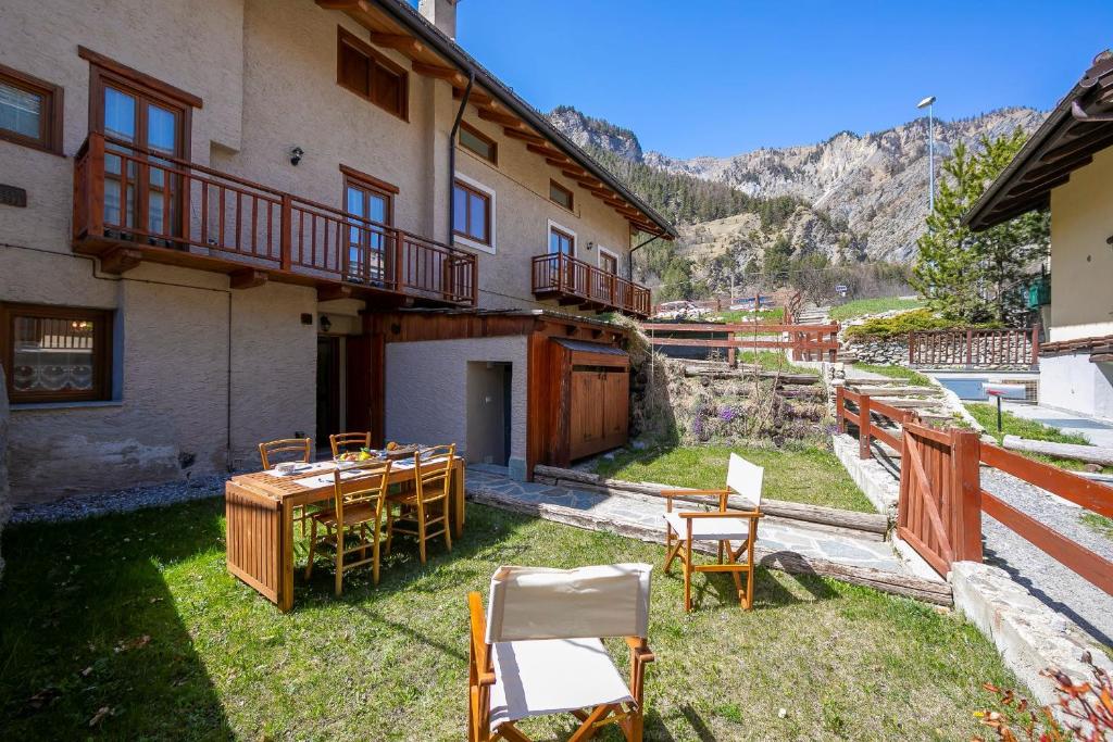 un patio avec des tables et des chaises en face d'un bâtiment dans l'établissement Baita La Ciaburna skiing nearby - Happy Rentals, à Bardonnèche
