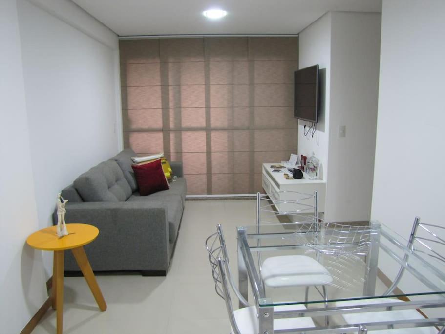 een woonkamer met een bank en een tafel bij Moderno apartamento perto da praia in Maceió