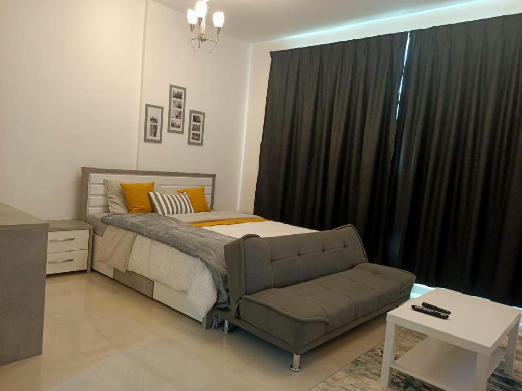 拉斯阿尔卡麦AL ALKEEM HEIGHTS的一间带床、沙发和窗户的卧室