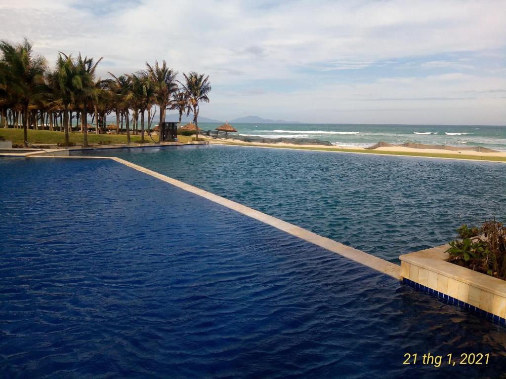 a swimming pool with the ocean in the background at Long Hải Villas trong Wyndham garden Cam Ranh in Cam Ranh