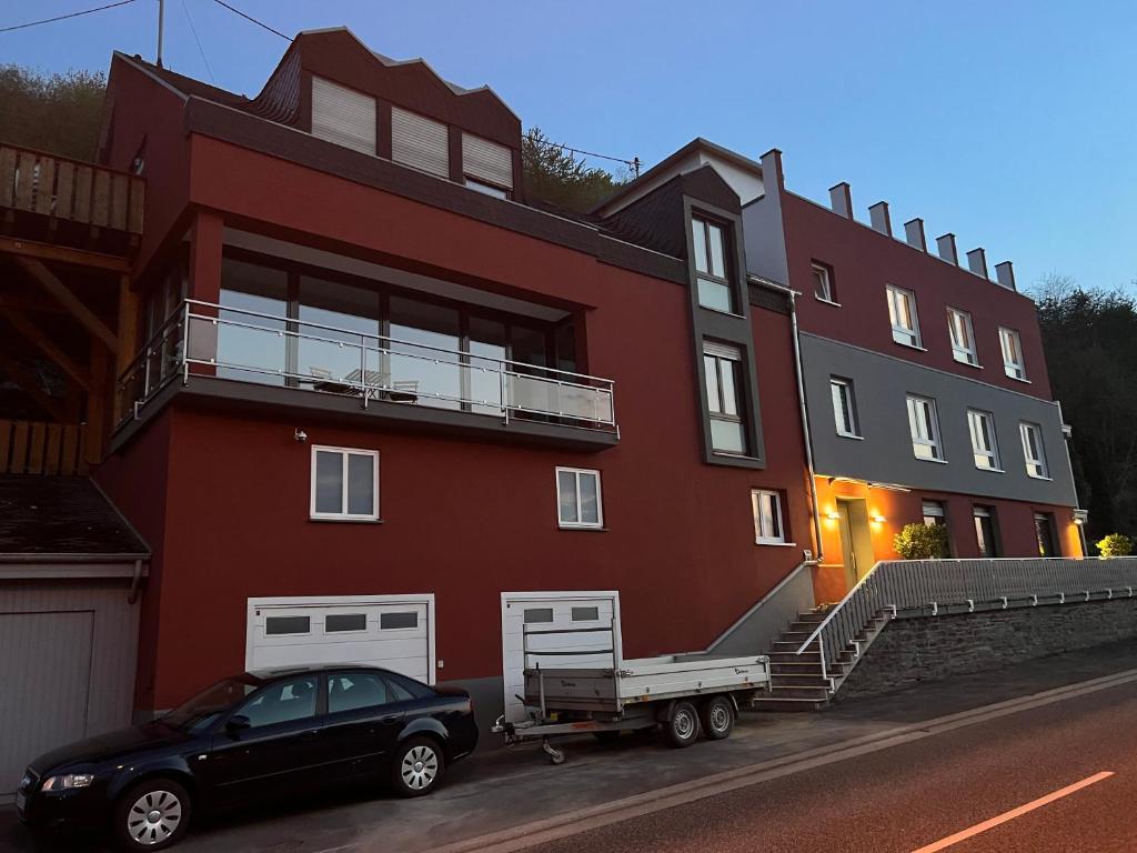 ein schwarzes Auto, das vor einem roten Gebäude parkt in der Unterkunft Moselflair in Bernkastel-Kues