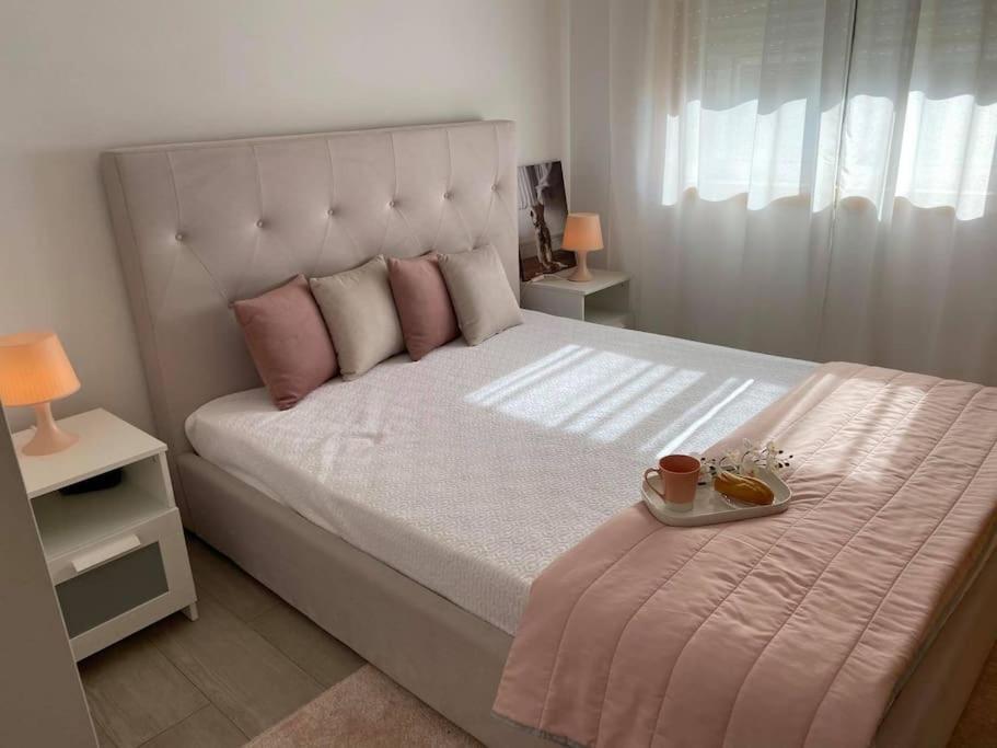 um quarto com uma cama grande e uma bandeja de comida. em DayDream Apartament em Viana do Castelo