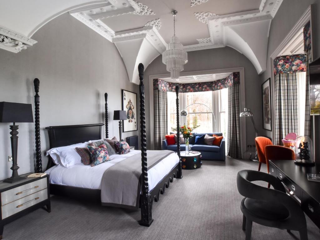een slaapkamer met een bed, een bank en een stoel bij The Meadowpark Bar, Kitchen & Rooms in Stirling