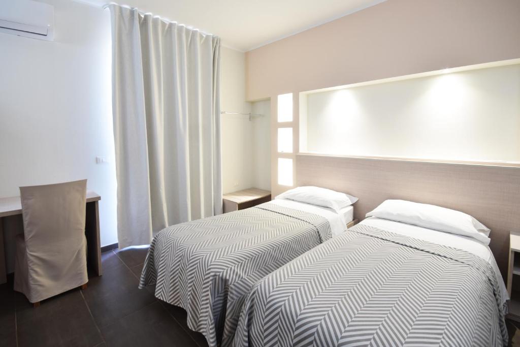 two beds in a hotel room with a window at Hotel La Siesta in Torino di Sangro