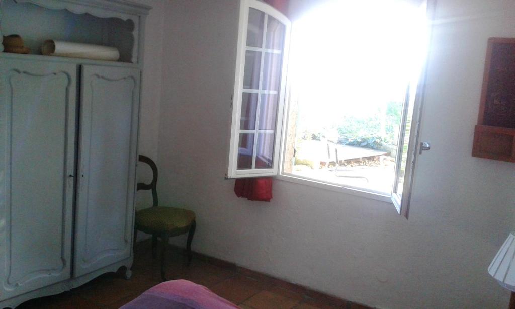 a room with a window and a chair and a dresser at Appartement d&#39;une chambre avec vue sur la mer jardin amenage et wifi a Hyeres a 2 km de la plage in Hyères