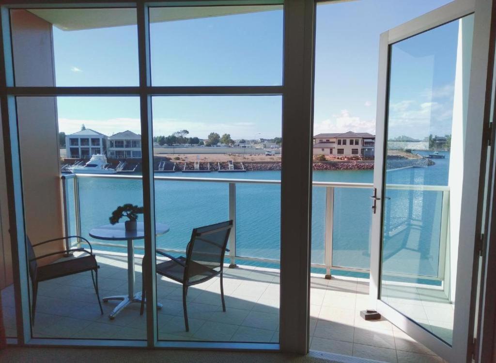 a balcony with a table and chairs and a view of the water at Apartment 3 Wallaroo Marina in Wallaroo
