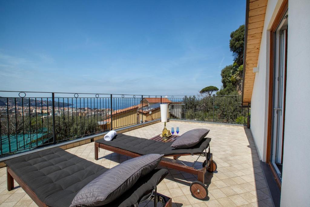 patio con sofá y mesa en el balcón en Eterea Charming Suites, en Sorrento