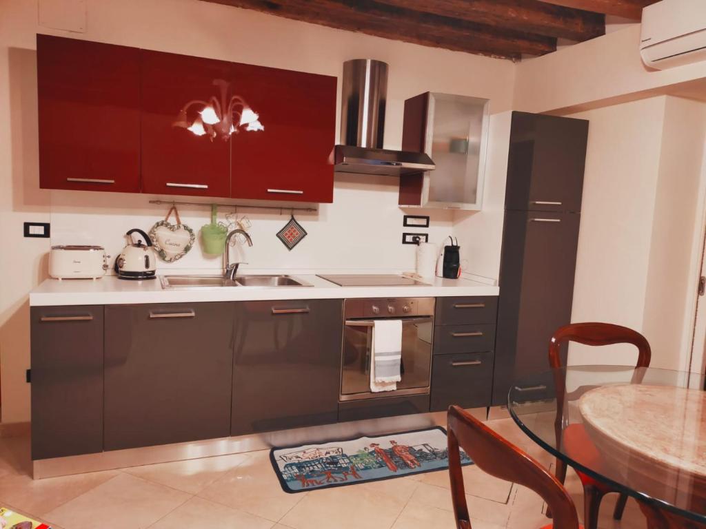 a kitchen with brown cabinets and a sink and a table at Le Pizzocchere in Venice