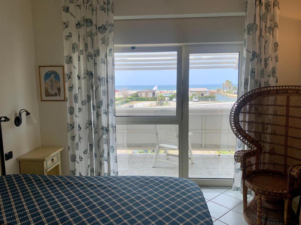 sypialnia z łóżkiem i oknem z widokiem w obiekcie Casa sul mare- House on the sea- VERSILIA w mieście Marina di Pietrasanta