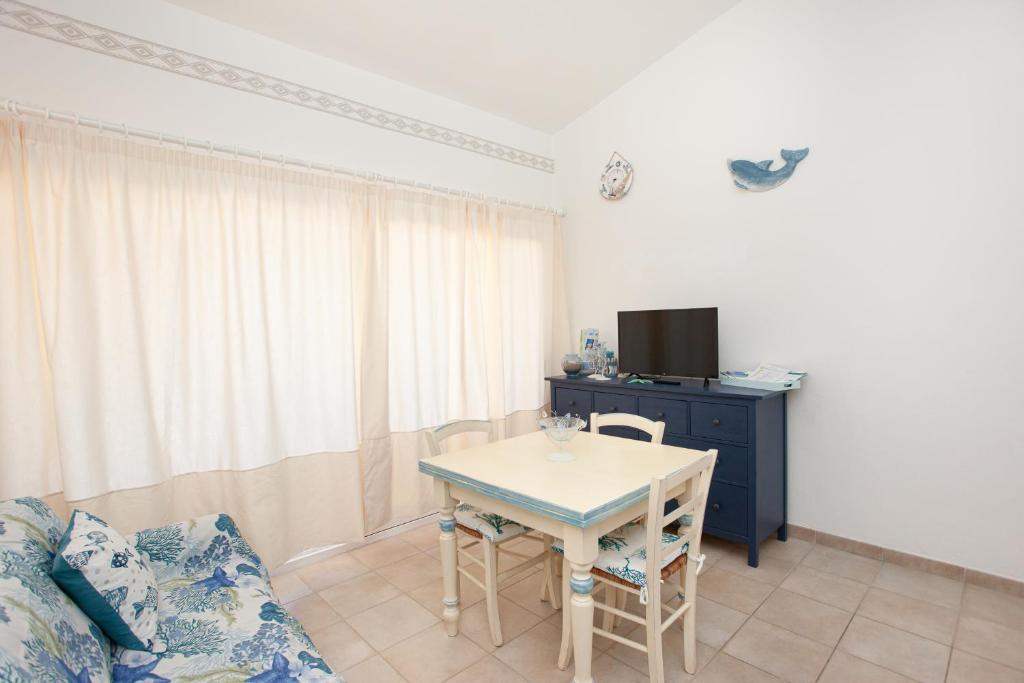 uma sala de estar com uma mesa e um sofá em Porto Coda Cavallo Beach House a 300 mt dal mare, con terrazza panoramica em San Teodoro