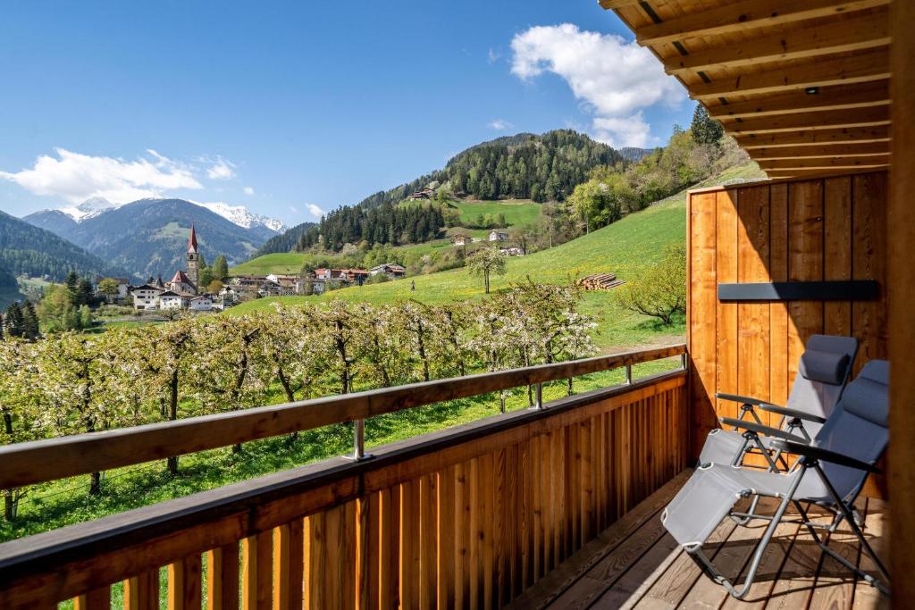 una terraza con sillas y vistas a las montañas. en Mayrhof Apartment Im Kirschgarten, en San Pancrazio