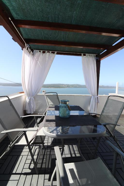 stół i krzesła na balkonie z widokiem na ocean w obiekcie BeGuest Lagoon House w mieście Nadadouro