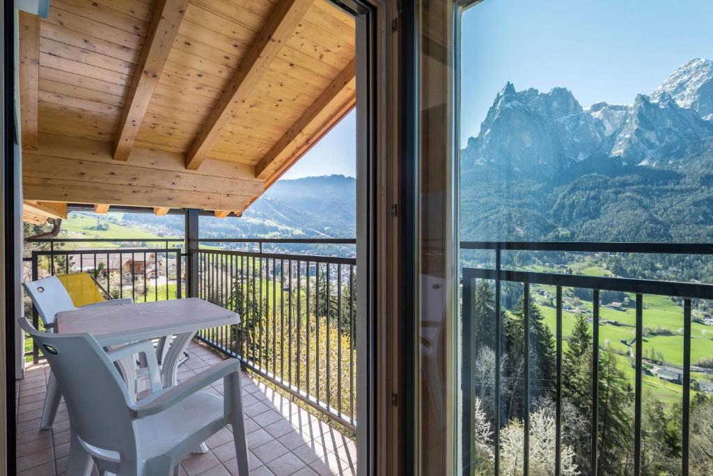 a balcony with a table and chairs and a view of mountains at Thusnelda Apartment B in Siusi