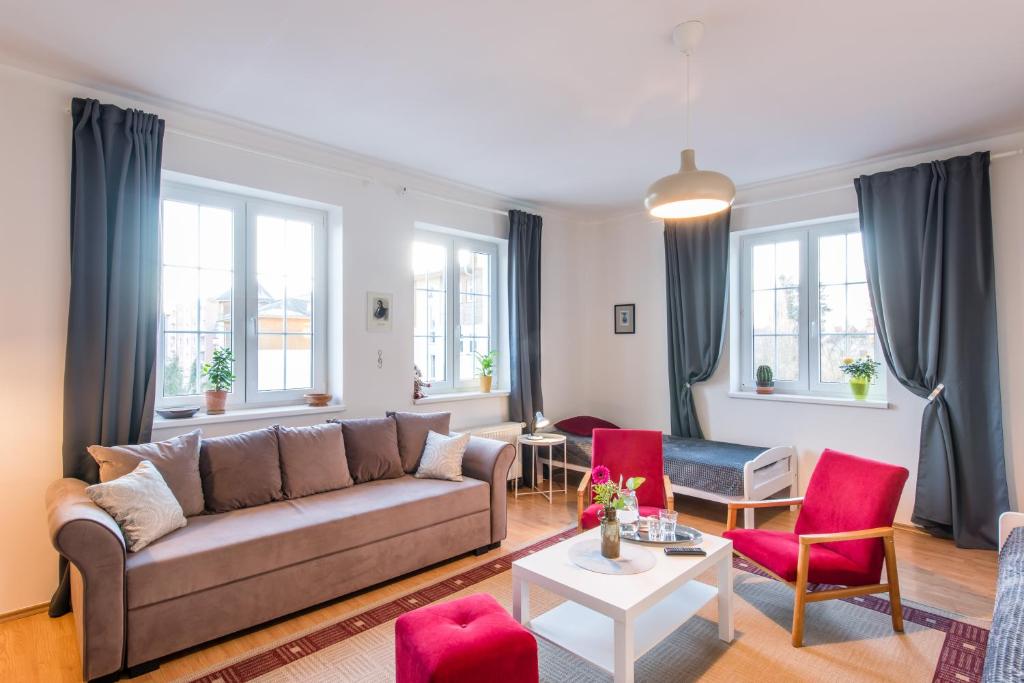 a living room with a couch and red chairs at Apartment CHOPIN in Mariánské Lázně