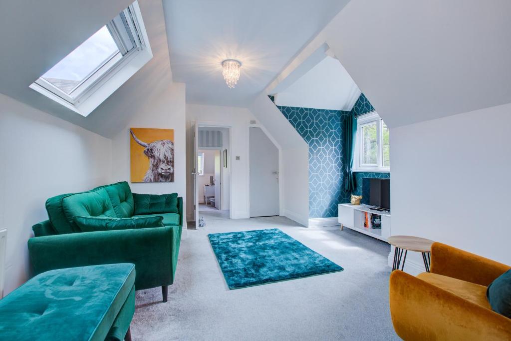 Una sala de estar con un sofá verde y sillas. en Luxury 3 Bedroom Apartment Close to Beach, Bournemouth & Meyrick Park, en Bournemouth