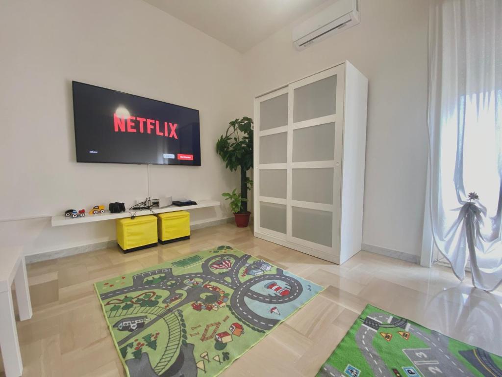 sala de estar con TV de pantalla plana en la pared en Guest House Service - Game Apartment, en Modugno