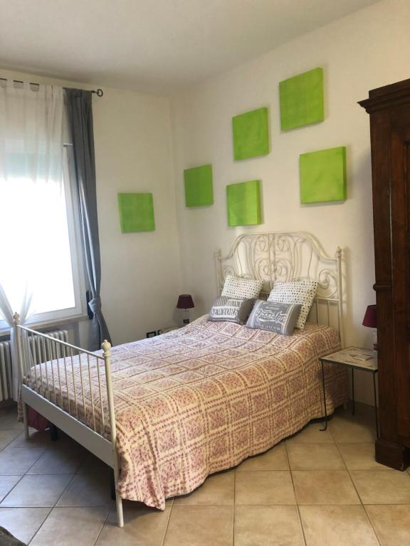a bedroom with a bed with green pictures on the wall at Da Scilla in Punta Marina