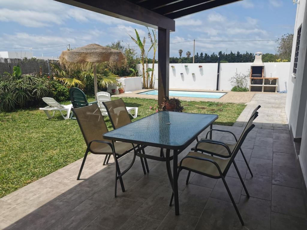 - une table et des chaises sur une terrasse avec piscine dans l'établissement Casa rural Ajolí, à El Palmar