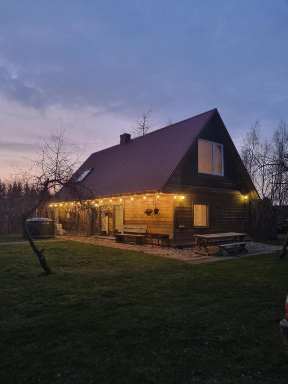 a large house with a gambrel roof with lights on it at Brīvdienu māja Rozes in Jūrkalne