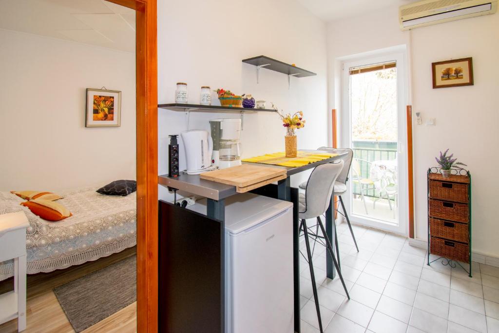 een kamer met een keuken met een tafel en een bed bij Studio Gabi, Premantura in Premantura