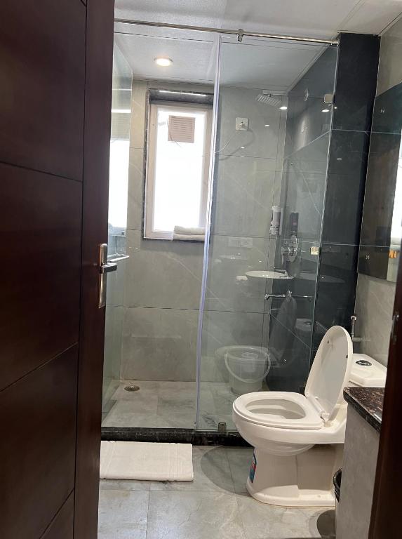 un bagno con wc e doccia in vetro di Windchime 853 a Gurgaon
