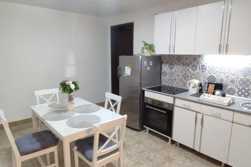 a kitchen with a table and a refrigerator at Well-located rural house on a spacious fenced lot in Novi Sad