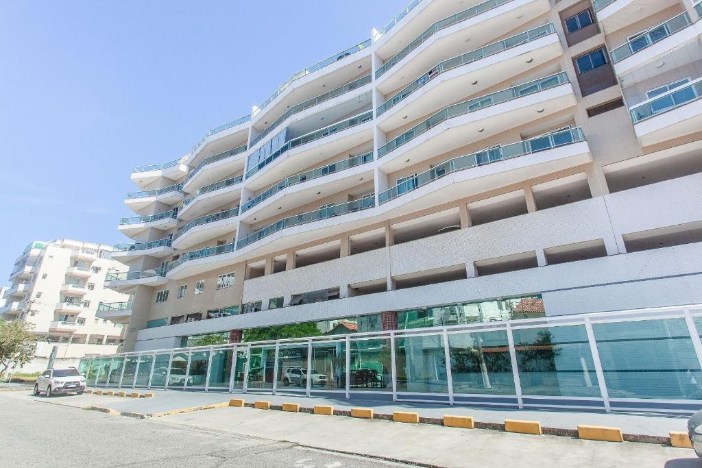 a large apartment building with a parking lot in front of it at CF02 Cobertura a 200m da Orla, Praia das Dunas in Cabo Frio