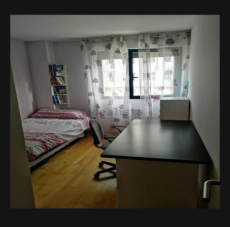1 dormitorio con escritorio, 1 cama y ventana en Habitación, en Pamplona