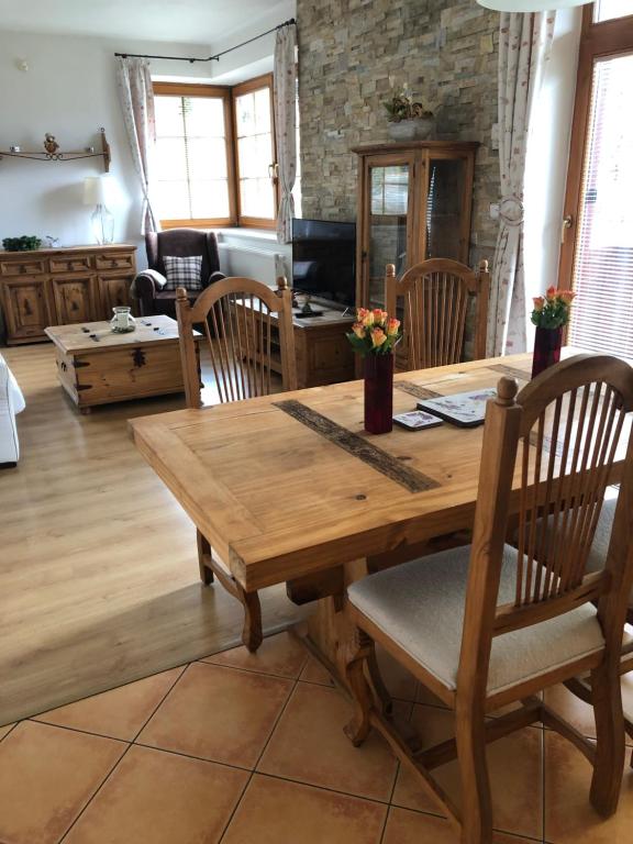 uma sala de jantar com uma mesa de madeira e cadeiras em Apartment 1 em Spindleruv Mlyn