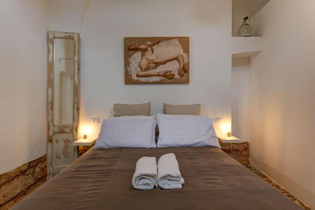 ein Schlafzimmer mit einem Bett mit zwei Handtüchern darauf in der Unterkunft Dimora Clessidra in Patù
