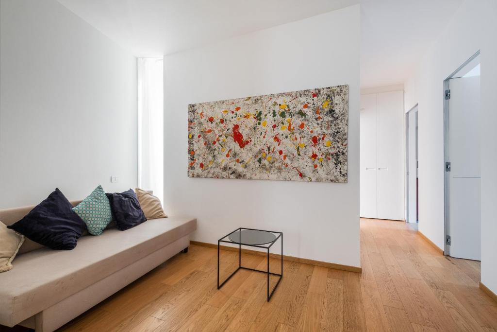 a living room with a couch and a painting on the wall at Santo Stefano Design Apartment by Wonderful Italy in Bologna