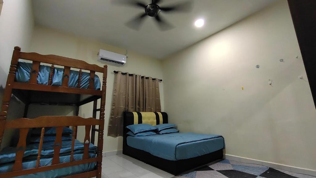 a bedroom with two bunk beds and a ceiling fan at Sentosa2Stay Gong Badak Kuala Terengganu in Kampong Gong Badak